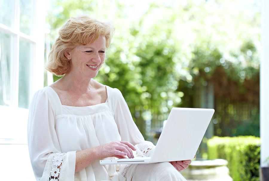 Woman Using A Laptop is a photograph by Ruth Jenkinson/science Photo Librar...