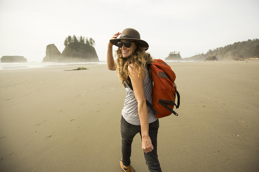A woman hiking along a remote beach. #3 Photograph by Jordan Siemens