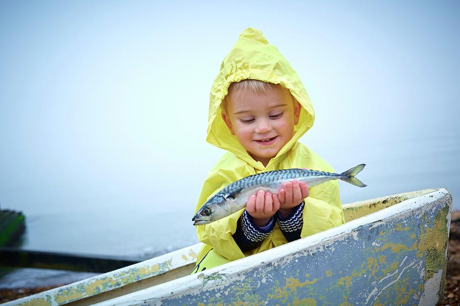 Fish Photograph - Boy Wearing Raincoat Holding A Mackerel #3 by Ruth Jenkinson