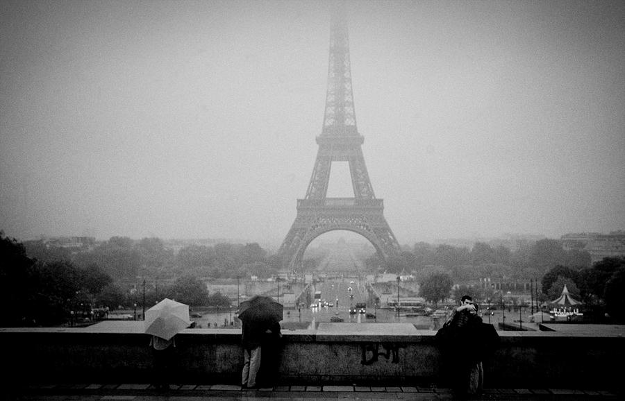 The couple in a misty rain at Parvis de Trocadero Paris and Eiffe during a misty drizziling morning. Photograph by Cyril Jayant