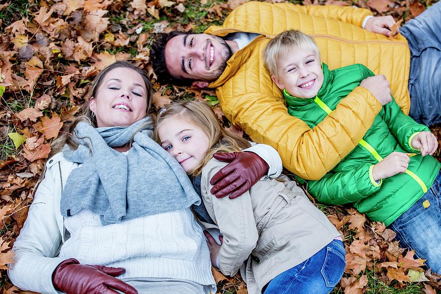 Family Lying On Dried Leaves #4 Photograph by Science Photo Library