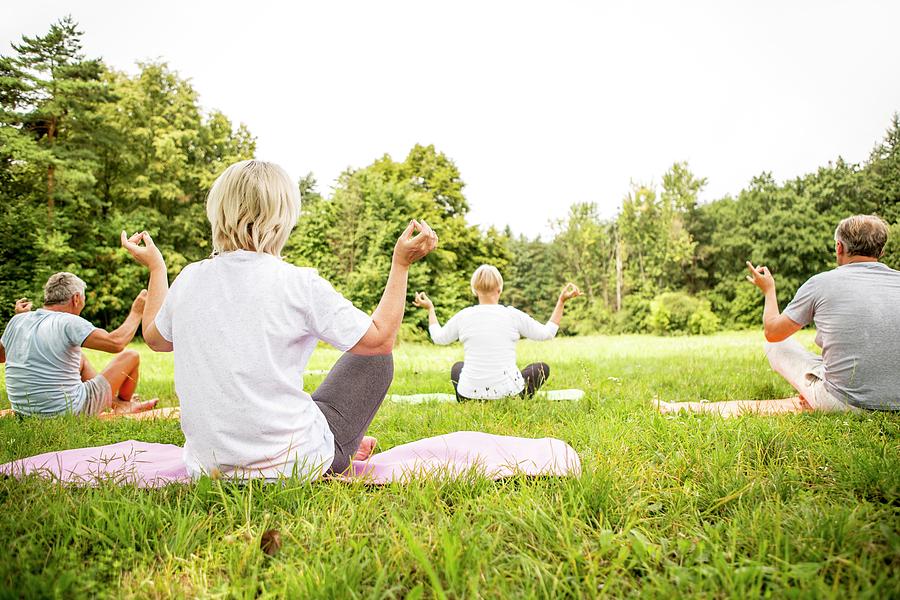 Four People Doing Yoga In Field Photograph By Science Photo Library 