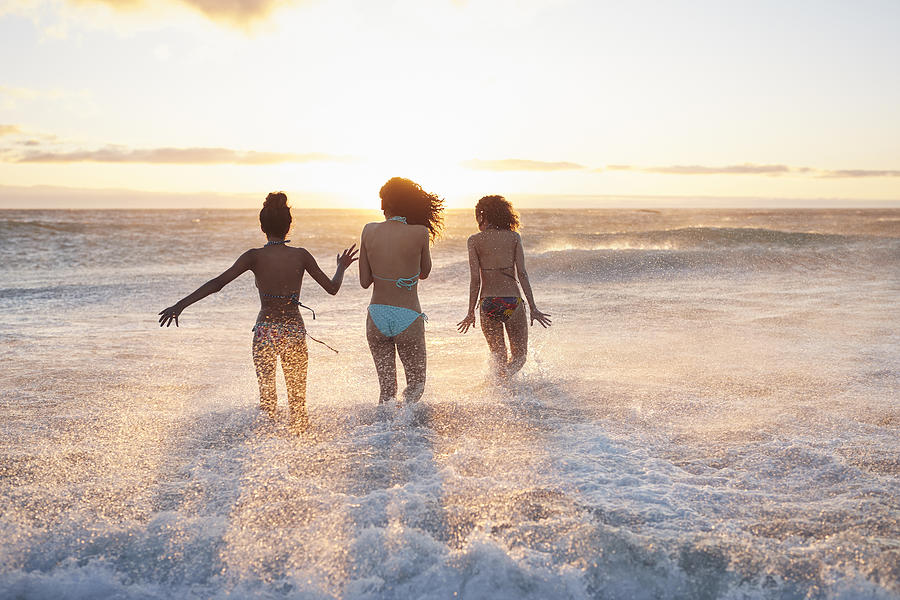 Three young women running in the water, at the beach #4 Photograph by Klaus Vedfelt