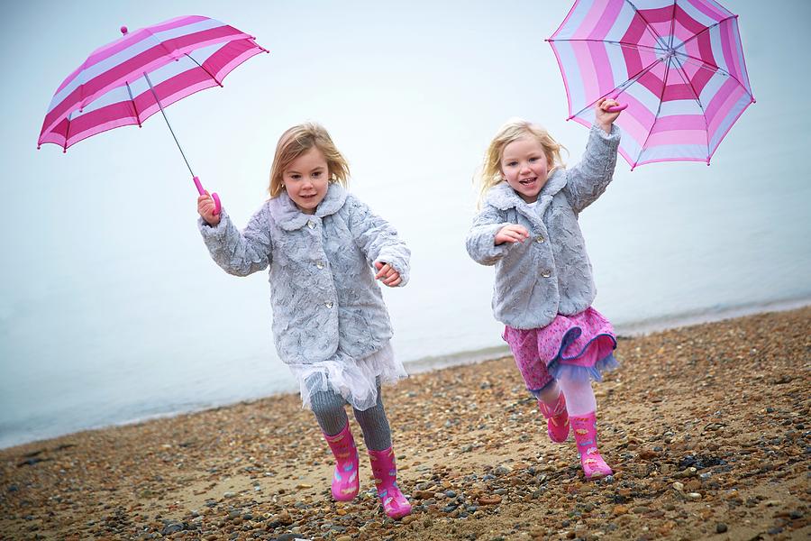 Two Girls On Beach Holding Umbrellas #4 Photograph by Ruth Jenkinson