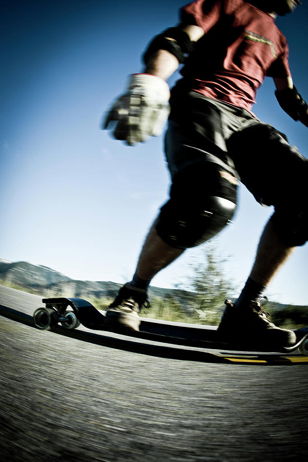 Landscape Photograph - Male Rides Long Board Down Paved Road #5 by Gabe Rogel