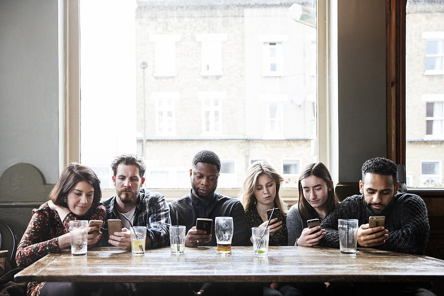 6 Friends At A Pub With Phones Photograph by Henrik Sorensen