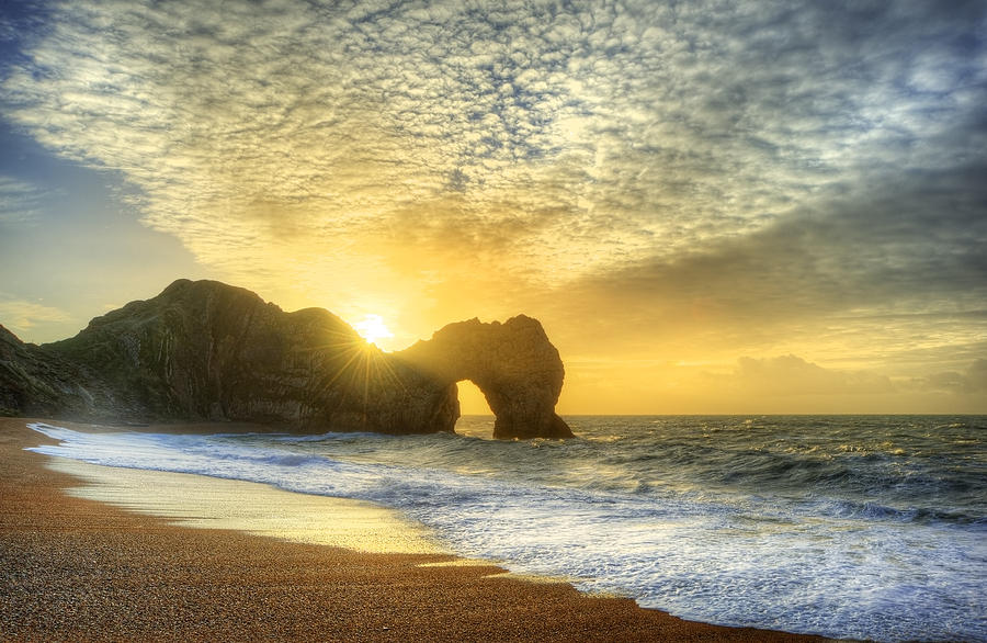 Vibrant sunrise over ocean with rock stack in foreground Photograph by ...