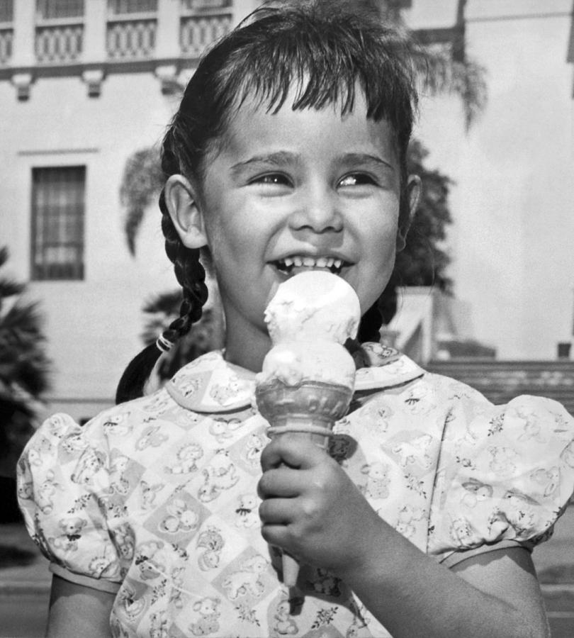 Black And White Photograph - Girl With Ice Cream Cone by Underwood Archives