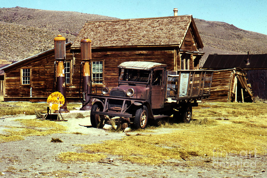 Vintage Photograph - A 1927 Dodge Graham sits next gas pumps at Bodie State Historic Park California 1971 by Monterey County Historical Society