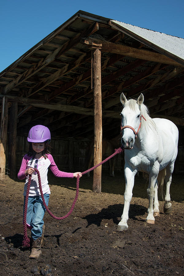 Barn Photograph - A 6-year-old Cowgirl Leads Her Horse by Topher Donahue