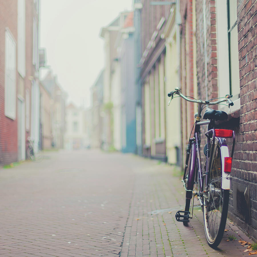 A Bicycle Parked Against A Wall In A Photograph by Cindy Prins