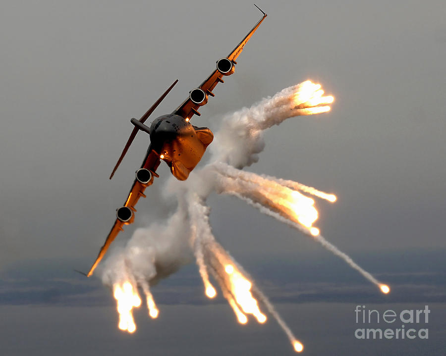 Airplane Photograph - A C-17 Globemaster IIi Releases Flares by Stocktrek Images