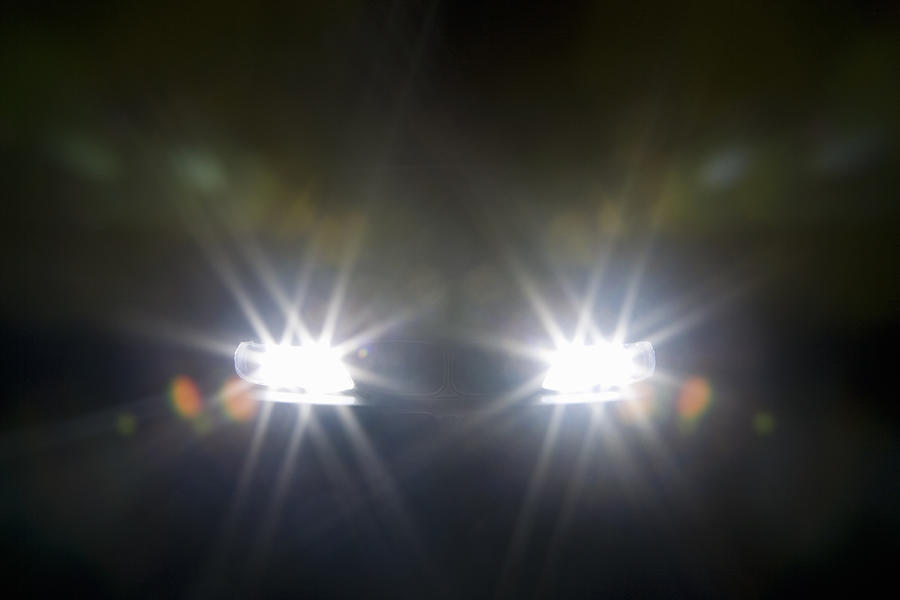 A car headlights illuminated at night Photograph by Caspar Benson