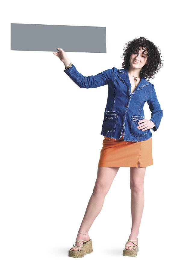 A Caucasian Girl With Brown Curly Hair Wearing A Denim Shirt And An Orang Skirt Stands With A Hand On One Of Her Hips And Her Other Hand Holding A Blank Sign Up To The Side Of Her Head Photograph by Photodisc