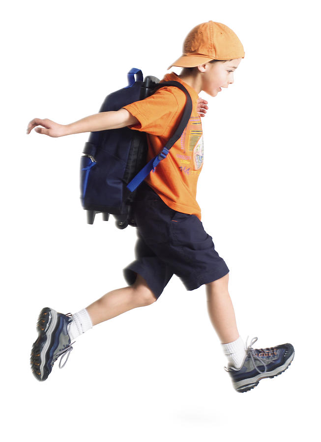 A Caucasian Little Boy With An Orange Ballcap And A Backpack Runs Along To School Photograph by Photodisc