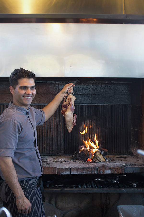 A Cook Hangs A Turkey Over Fire Pit Photograph By Robert Benson