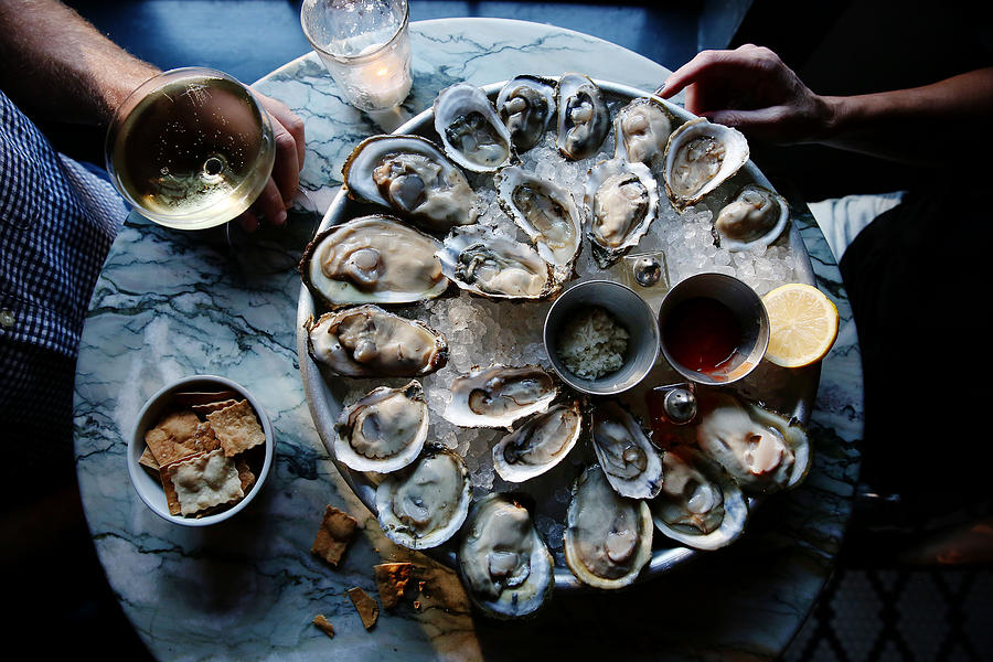 A couple enjoying raw oysters Photograph by Marianna Massey