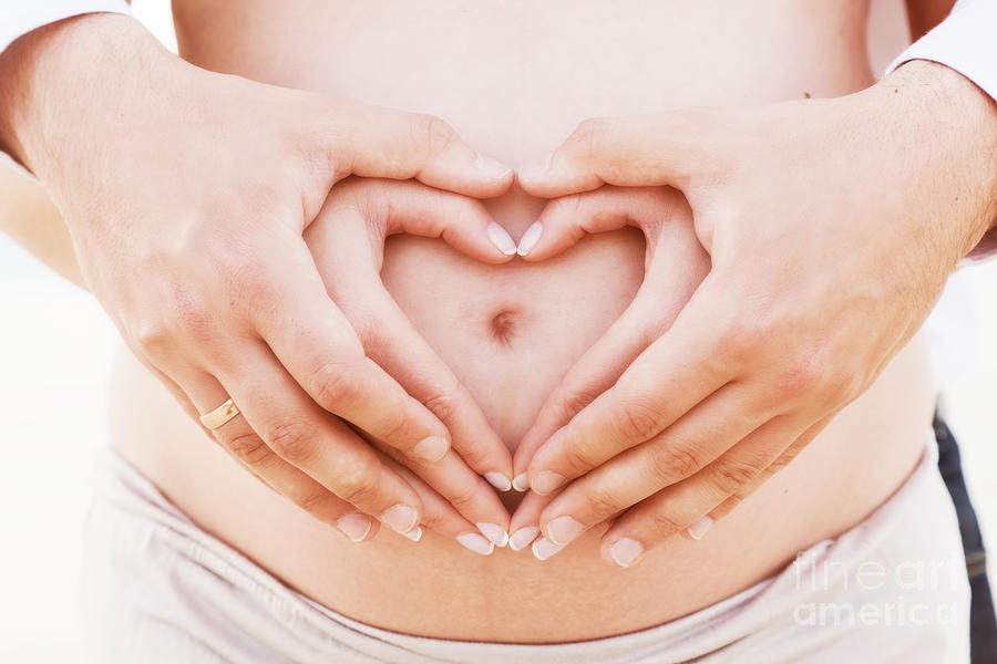 A Couple Making A Heart Shape On The Pregnant Belly With Their Hands Photograph