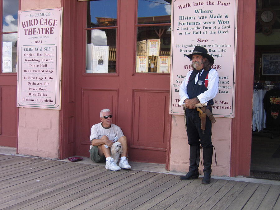 A dog and a re-enactor rest in the front of the Bird Cage Theater Tombstone Arizona Photograph by David Lee Guss