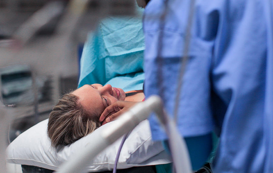 a Doula comforts a pregnant woman moments before her caesarean section. Photograph by Petri Oeschger
