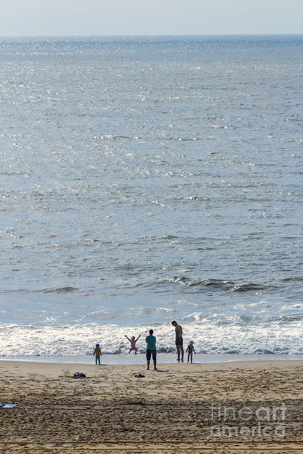A family enjoys the early morning Atlantic beach at Ocean City MD  Photograph by William Kuta