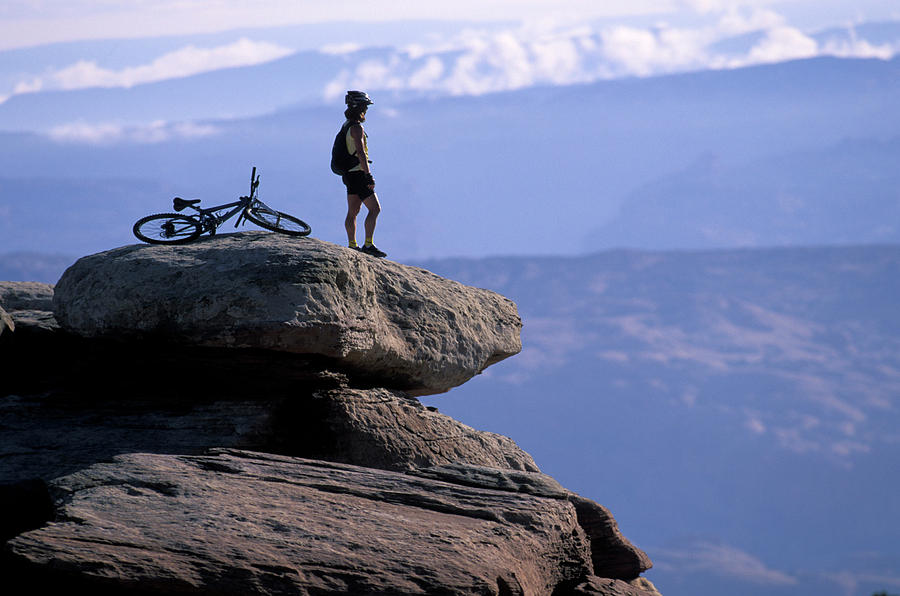 Spring Photograph - A Female Mountain Biker Stands by Corey Rich