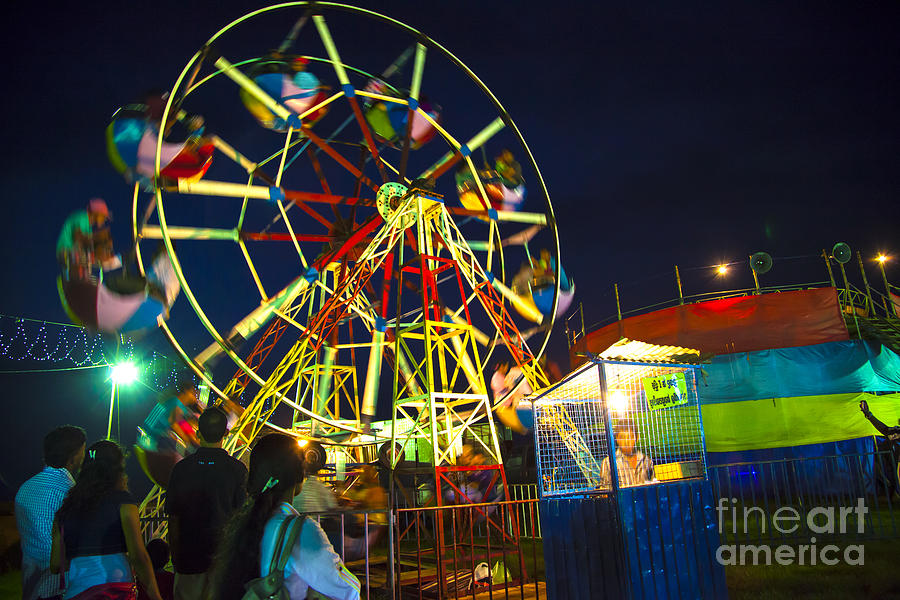 A Ferris Wheel veers by a big folk festival Photograph by Gina Koch