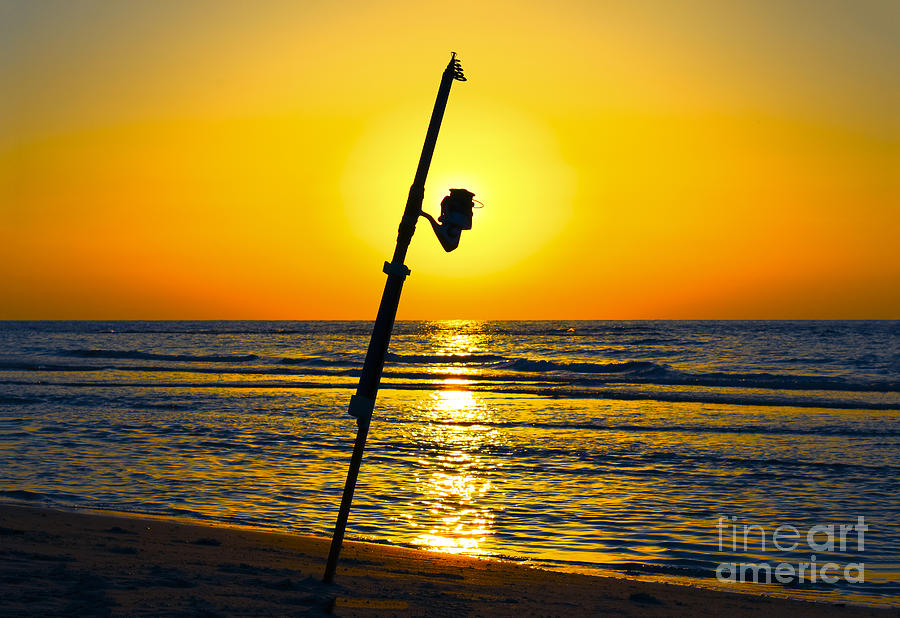 A fishing rod on the shore at sunset by Ido Dromi