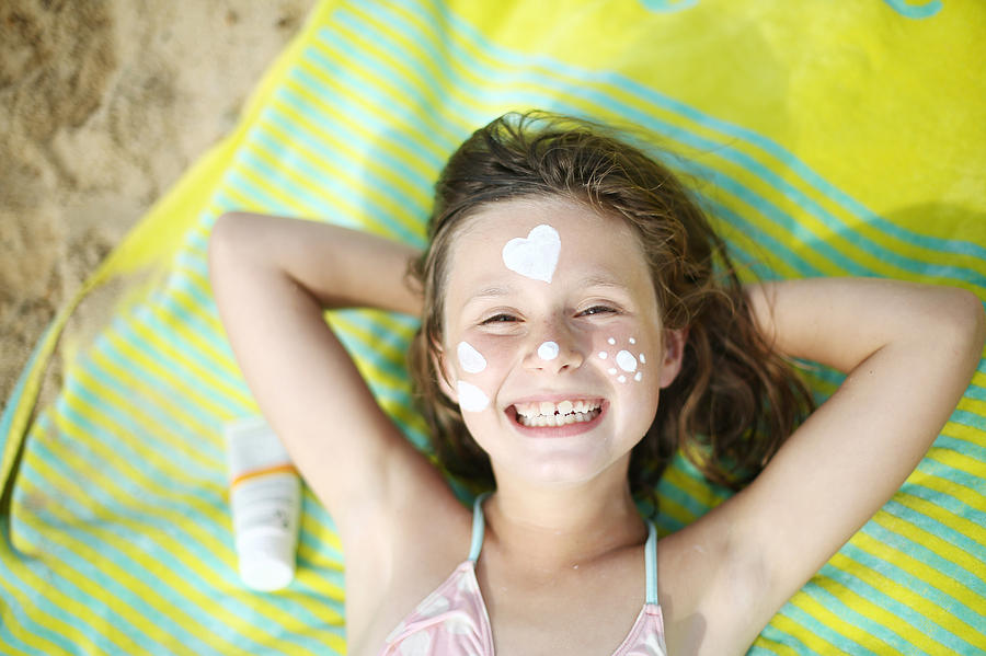 A girl with sunscreen on the face on the beach Photograph by Catherine Delahaye