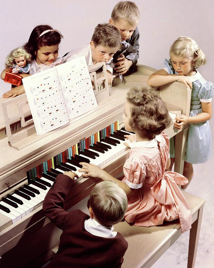 A Group Of Children At The Piano Photograph by Herbert Matter
