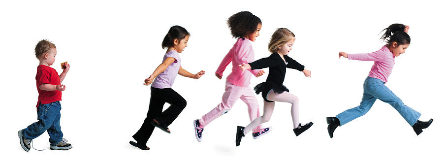 A Group Of Girls Run Forward As A Little Boy Strolls Slowly Behind Them Photograph by Photodisc