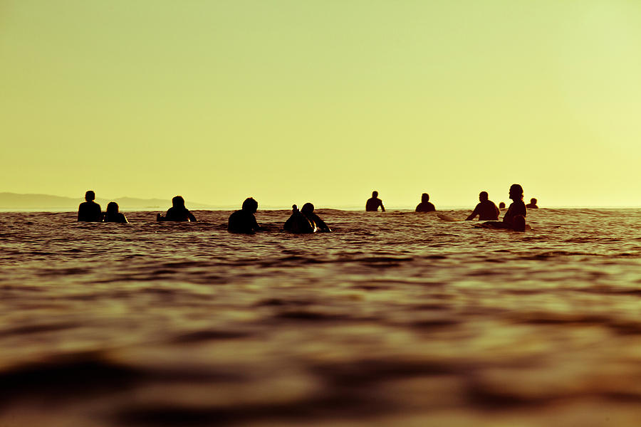 Sunset Photograph - A Group Of Surfers Wait For Waves by Kyle Sparks