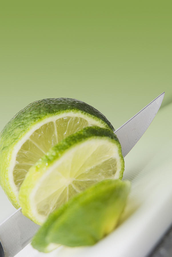Fruit Photograph - A Knife Cutting A Lime by Marlene Ford