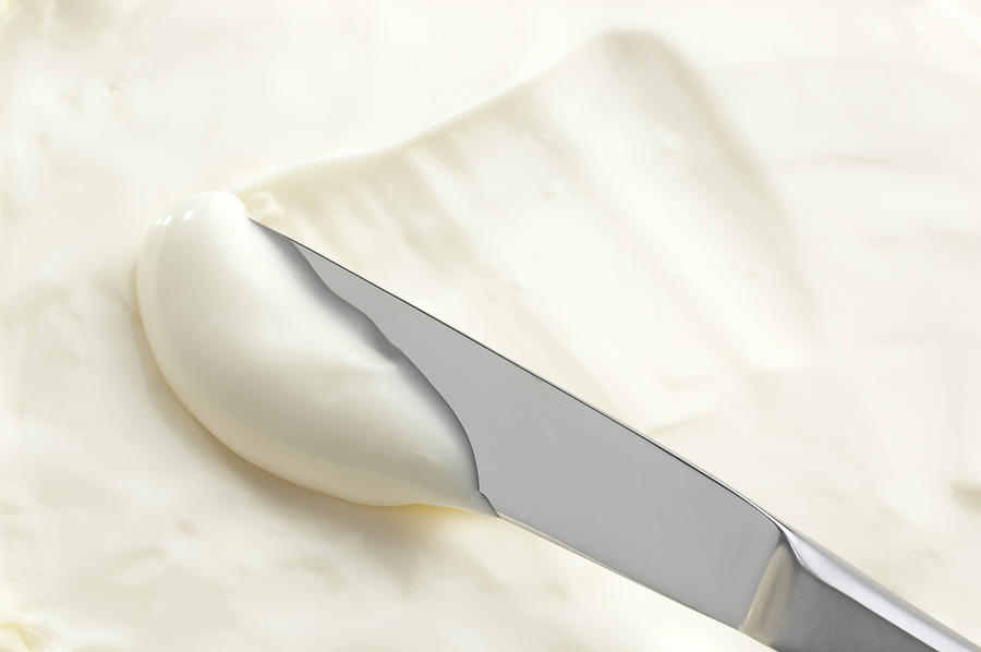 A knife swiping into some cream cheese Photograph by Sinan Kocaslan