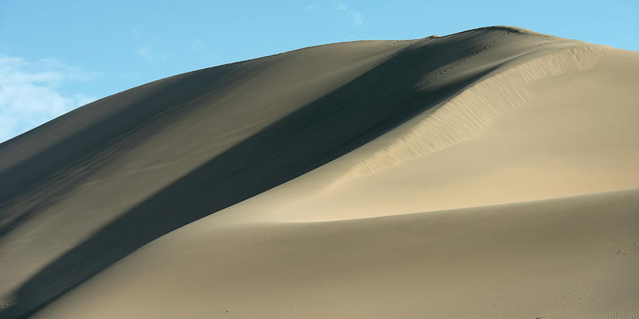 A Large Sand Dune Against A Blue Sky Photograph by Keith Levit / Design Pics