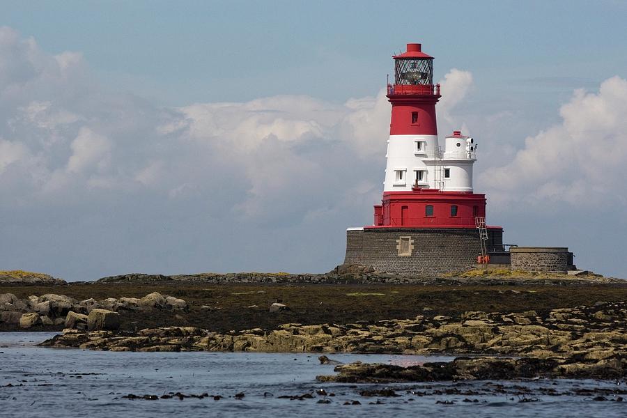 A Lighthouse On A Shoreline Photograph by John Short