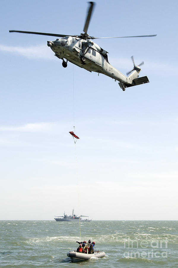 Transportation Photograph - A Litter Is Lowered From A Sh-60b by Stocktrek Images