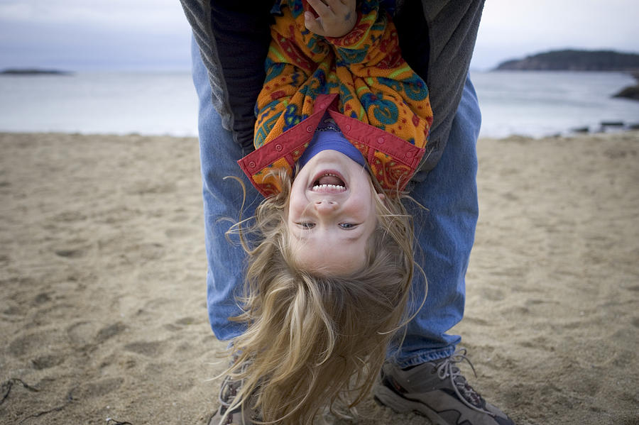 Beach Photograph - A Little Girl Is Held Upside by David McLain