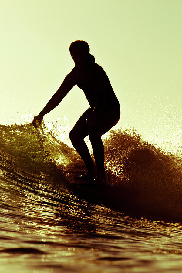 Sunset Photograph - A Male Surfer Rides A Longboard by Kyle Sparks