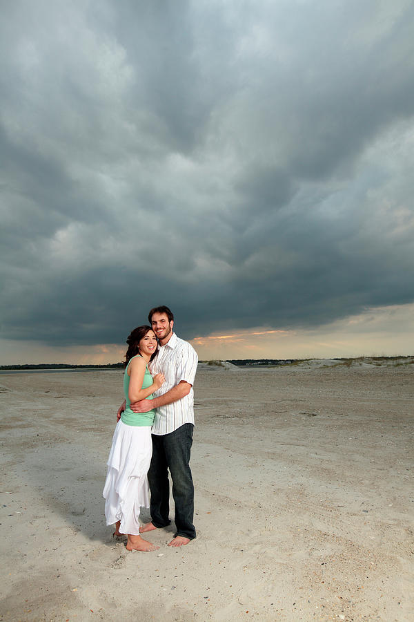 Sunset Photograph - A Man And A Woman Embrace, Standing by Logan Mock-Bunting