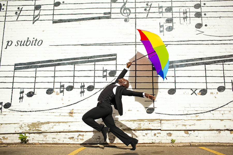 A man jumping and dancing with an umbrella outside Photograph by Adam Hester