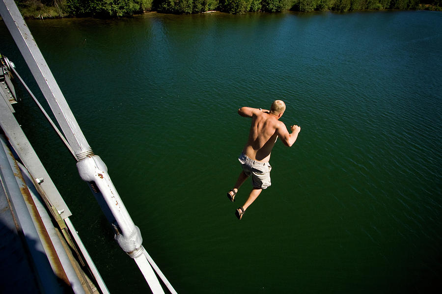 A Man Jumps Off A Bridge Into A River Photograph by Kirk Mastin Fine