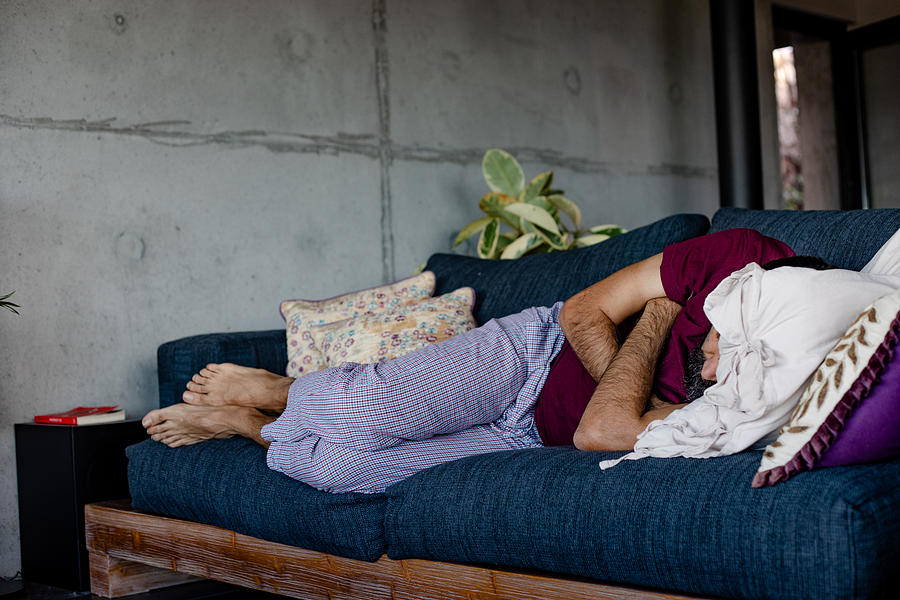 A man lying down on a sofa, sleeping Photograph by Photographer, Basak Gurbuz Derman