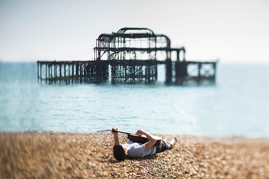 A Man Lying On A Beach With A Guitar Photograph by Richard Boll