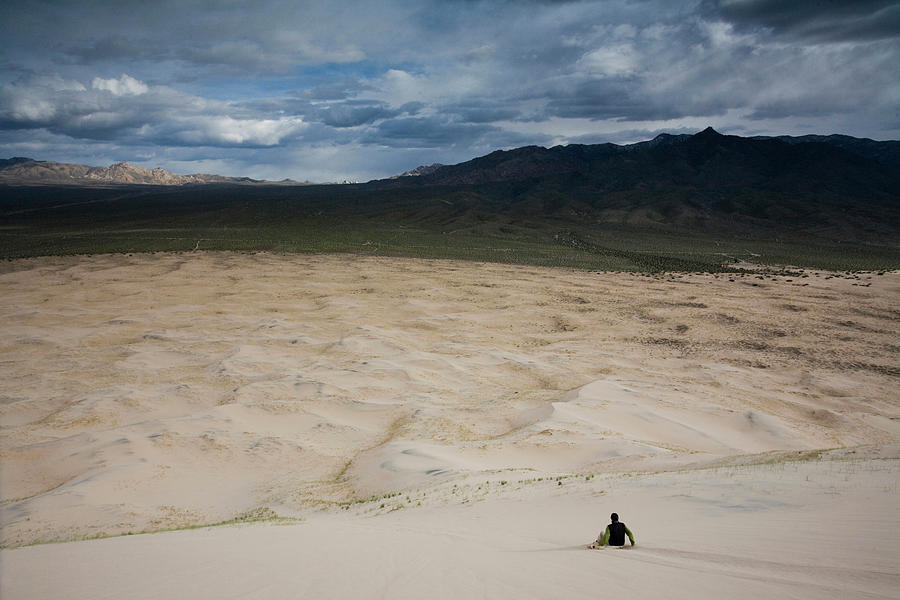 Mountain Photograph - A Man Slides Down The Sand Dunes by Michael Hanson