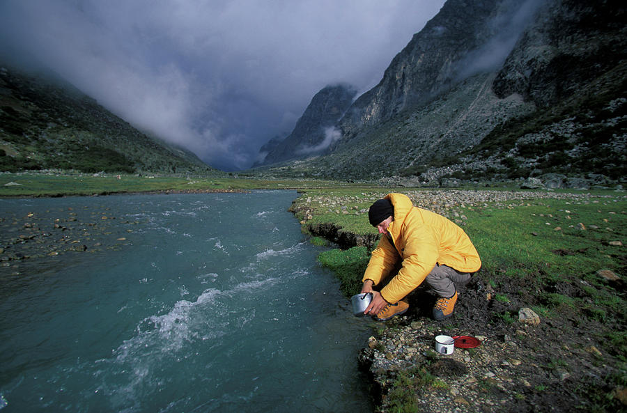 Mountain Photograph - A Man Washes Pots And Pans by Corey Rich