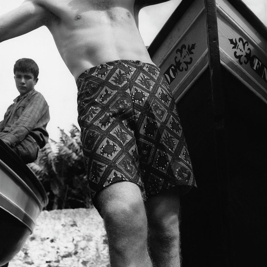 A Man Wearing Patterned Shorts And A Teenage Boy Photograph by Leonard Nones