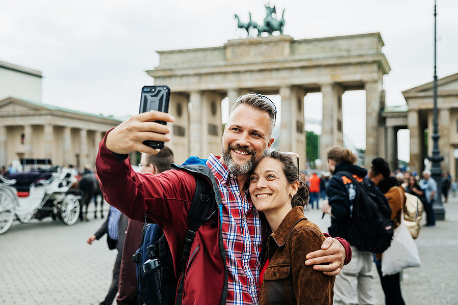 A Mature Couple Take A Selfie Together In Front Of Brandenburg Gate in Berlin Photograph by Hinterhaus Productions