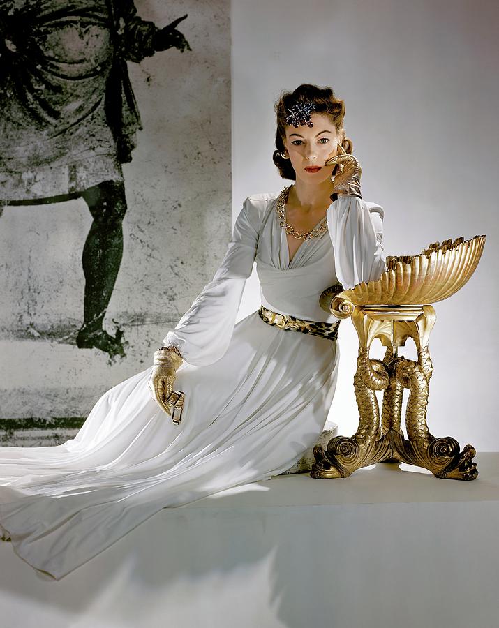 A Model Leaning On A Gold Pedestal Photograph by Horst P. Horst