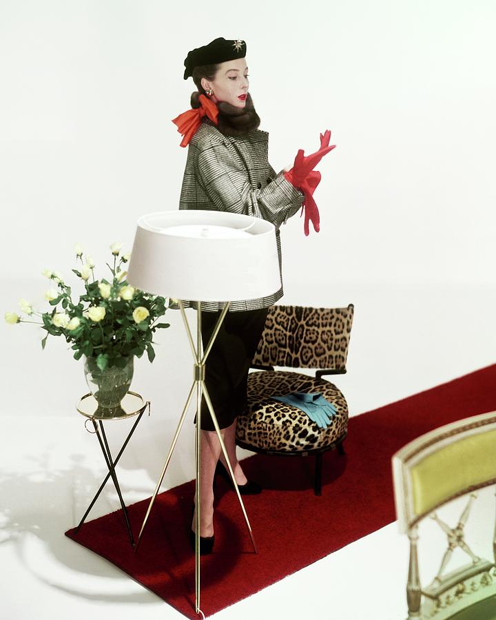 A Model Surrounded By Assorted Furniture On A Red Photograph by Horst P. Horst
